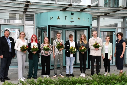 Sieben neue Auszubildende hat die Stadt Achim am Freitagmorgen im Rathaus begrüßt. Sie stehen nebeneinander vor dem Haupteingang des Rathauses.